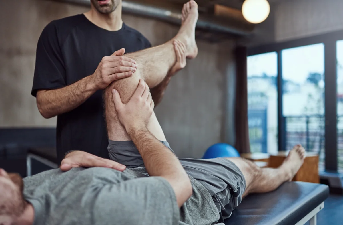 A physiotherapist assessing a patient’s knee movement
